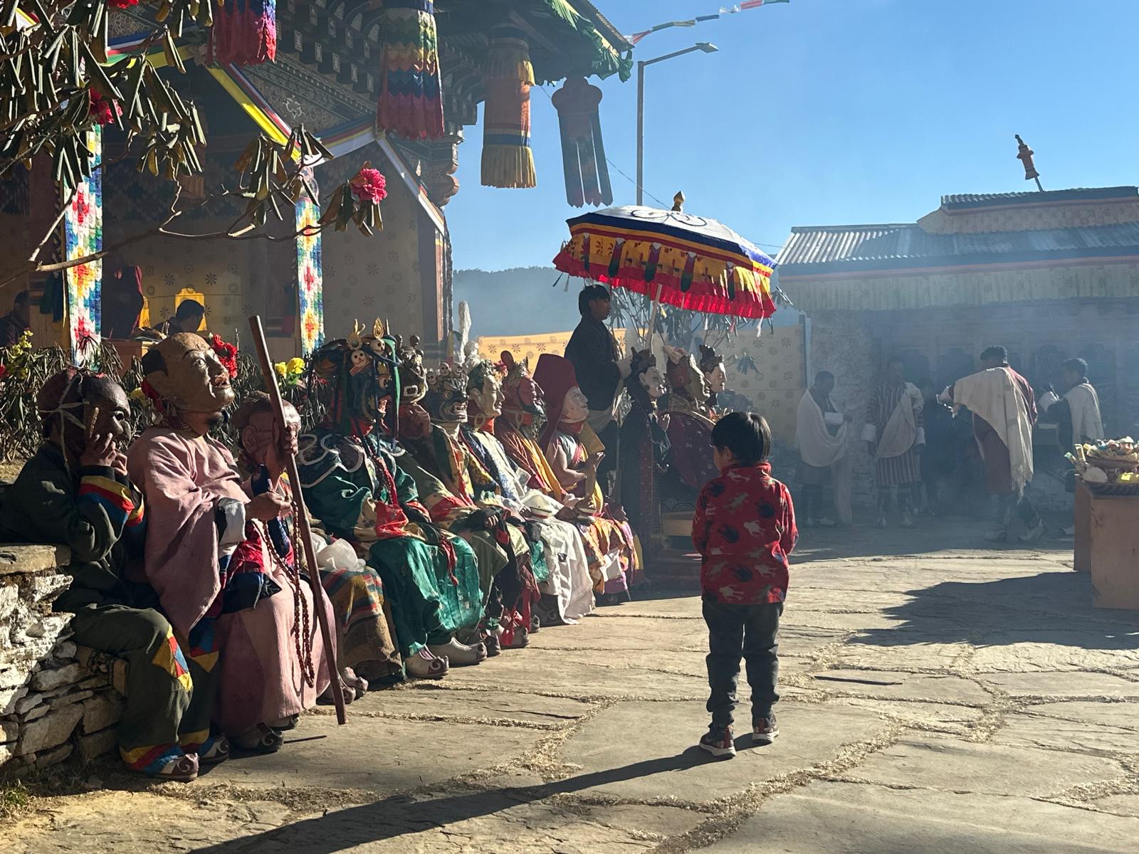 Performers and audience gathered outside a monastery at the Shingkar Dechenling Tshechu in Bhutan.
