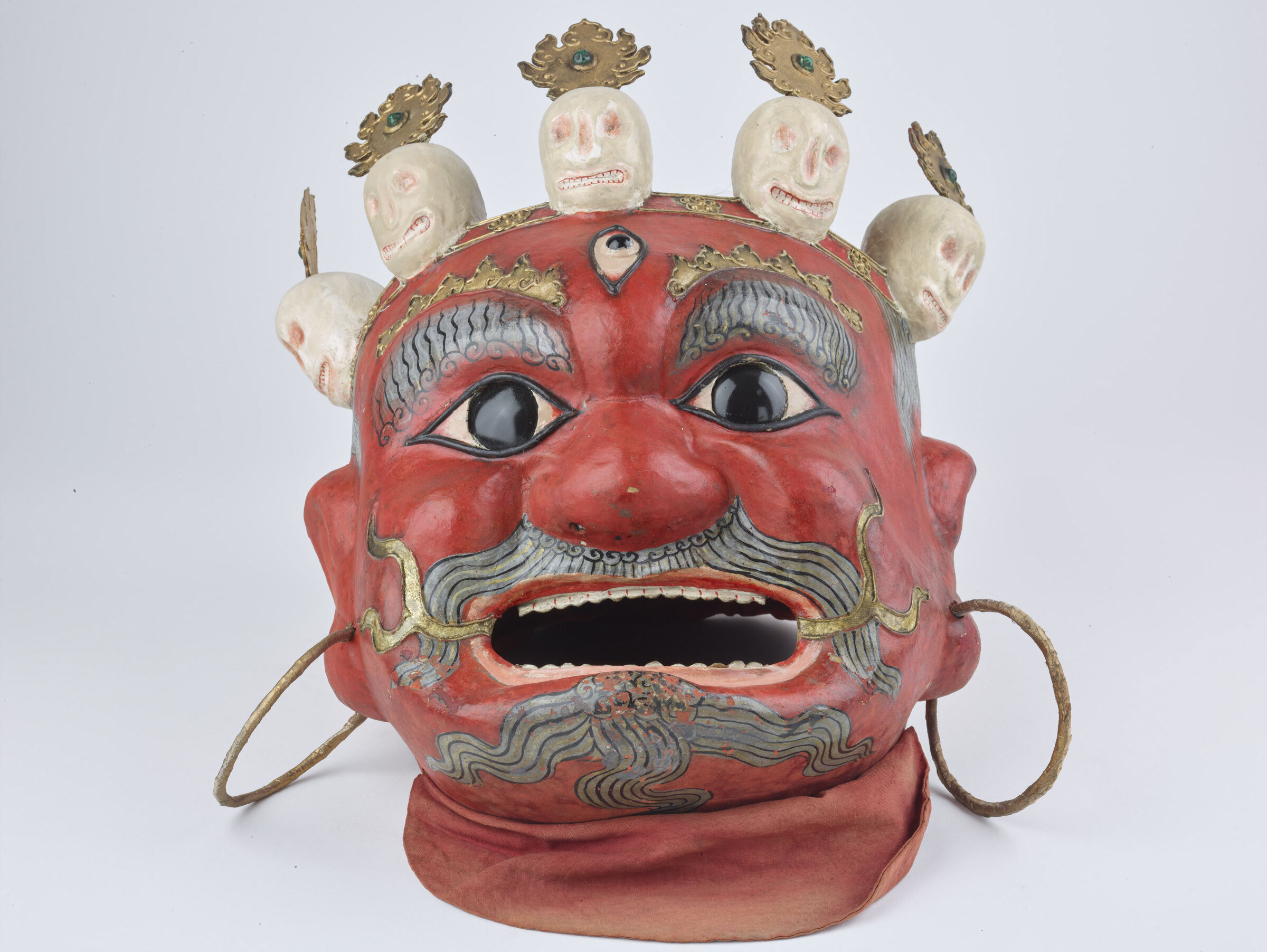 A red-faced wrathful mask with a crown of small skulls, the Guru DrakMar mask.