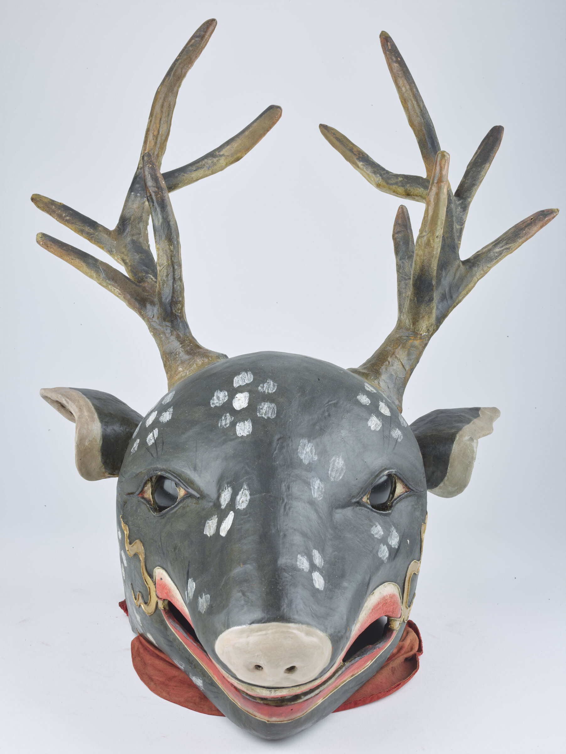 A painted papier-mâché deer mask with large antlers, the Shawa mask.